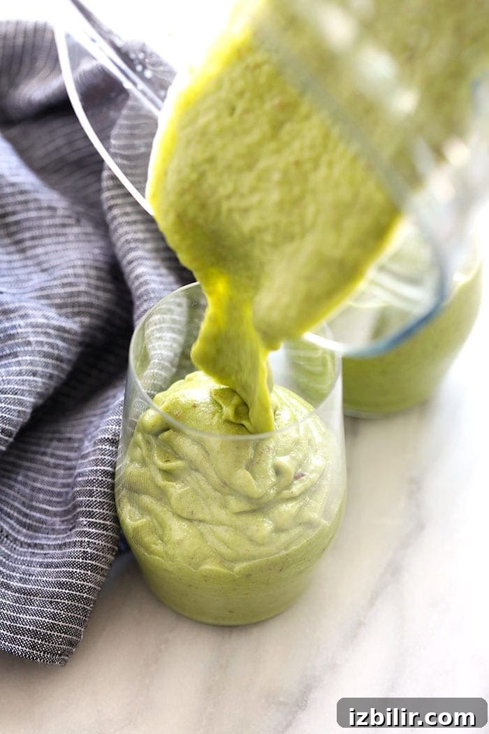 Pouring a green smoothie into a glass