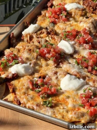 Queso Fundido sheet pan nachos with melted cheeses and chorizo