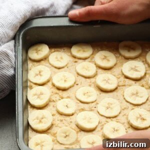 topping batter with banana slices