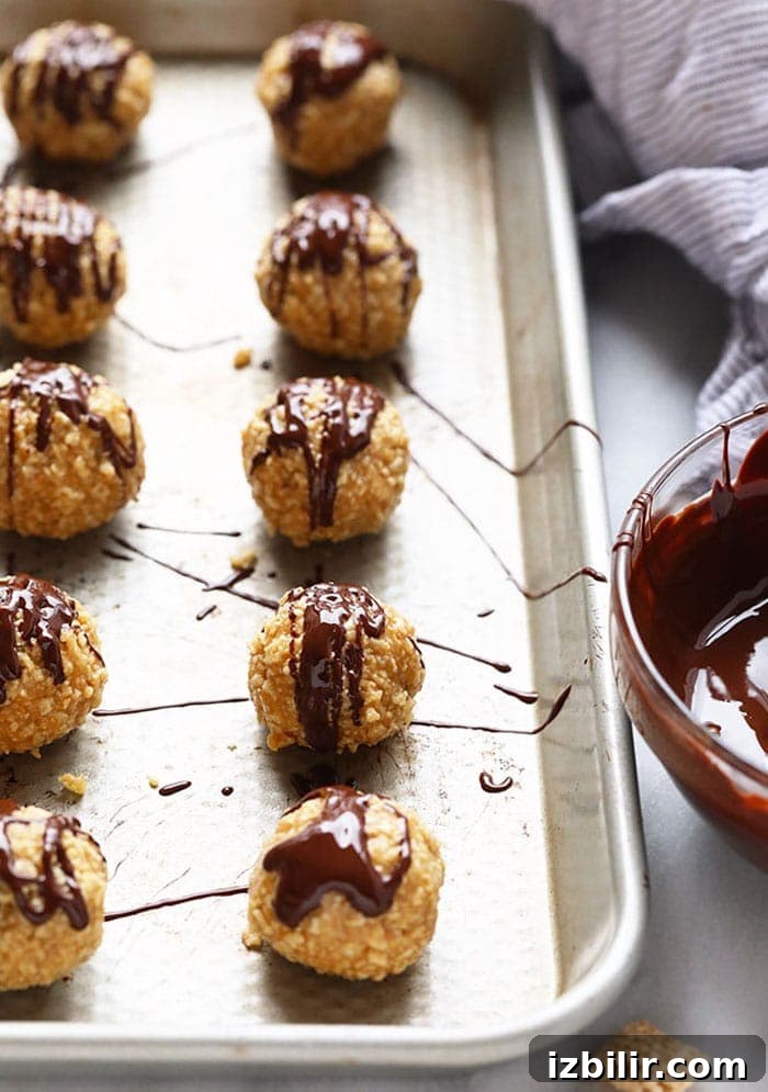 No-Bake Peanut Butter Honey Chex Cereal Balls 5 A tray of chocolate covered peanut butter balls on a baking sheet.