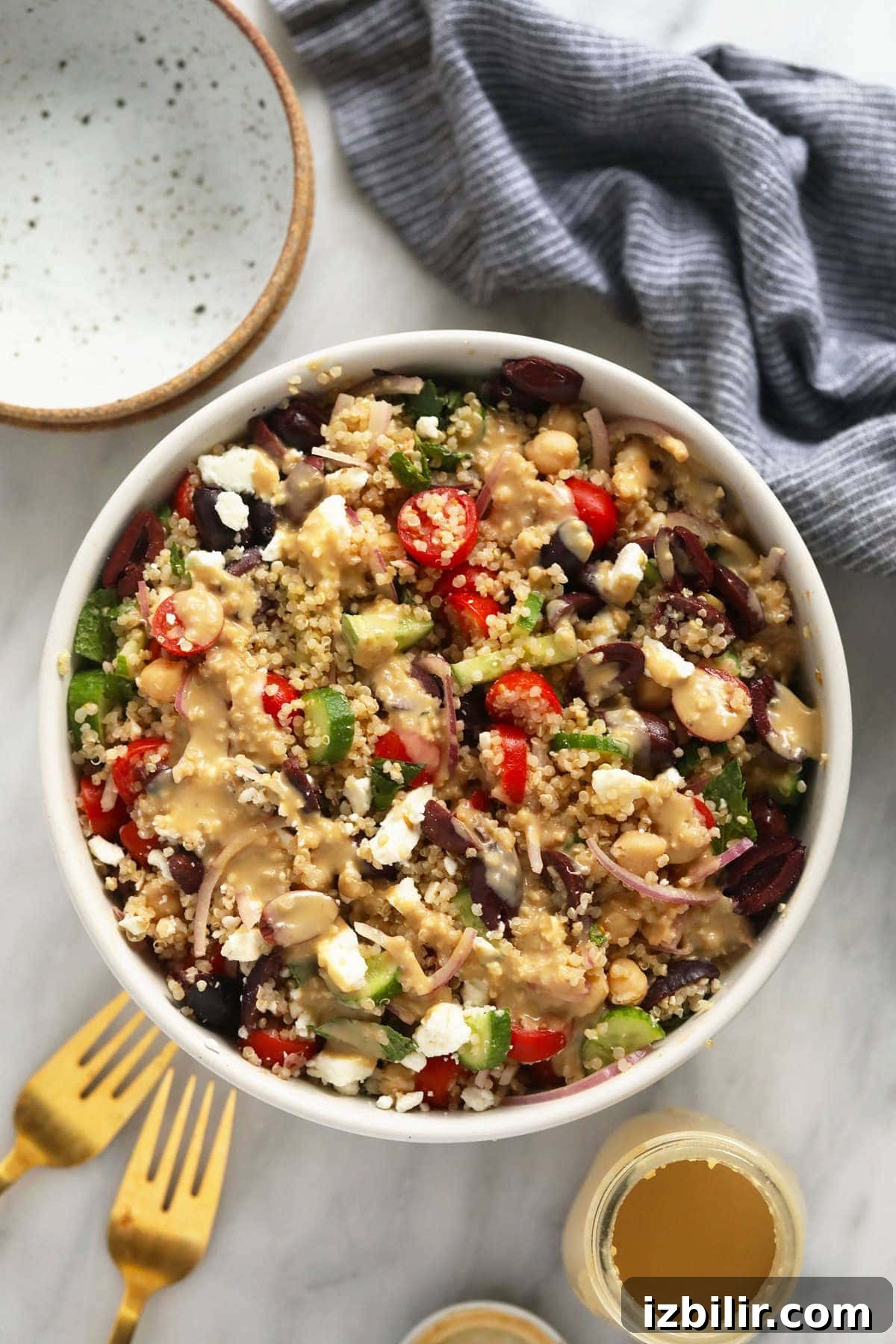 quinoa salad in bowl with hummus dressing.