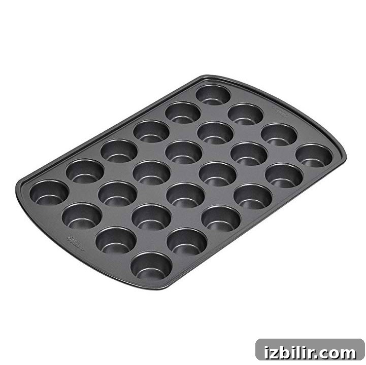 a black muffin pan with 12 holes perfect for making pumpkin peanut butter cups.
