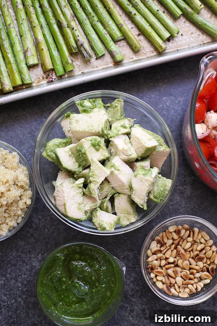 Pesto chicken in a bowl ready to be combined with asparagus