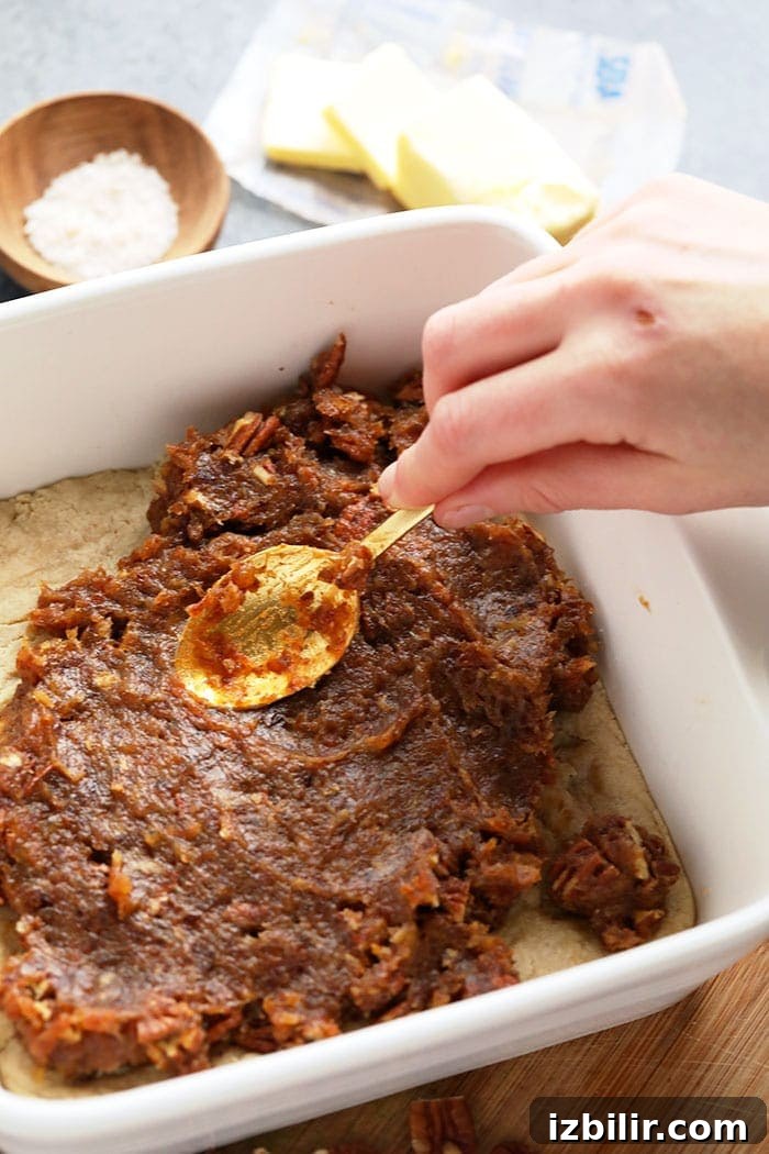 Spreading date caramel over almond shortbread crust Spreading date caramel over shortbread crust