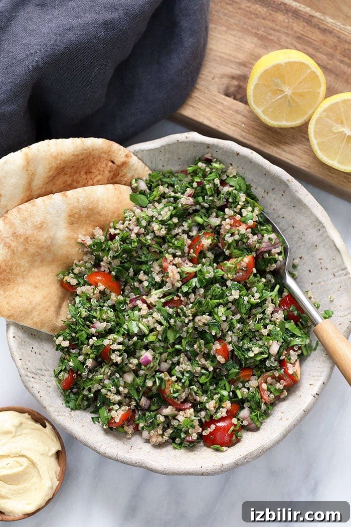 Quinoa Tabouli - fresh, simple, and protein-packed A bowl of quinoa tabouli with a spoon in it.