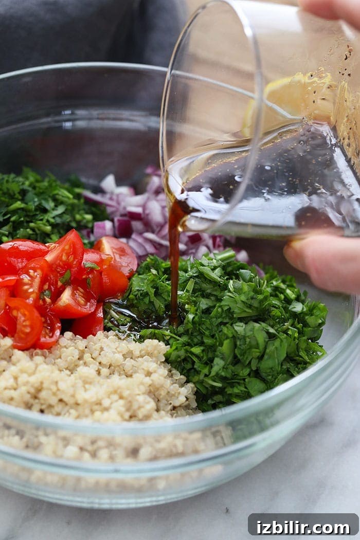 Quinoa Tabbouleh Recipe: Fresh Mediterranean Salad 4 Dressing being poured over the quinoa tabouli salad.