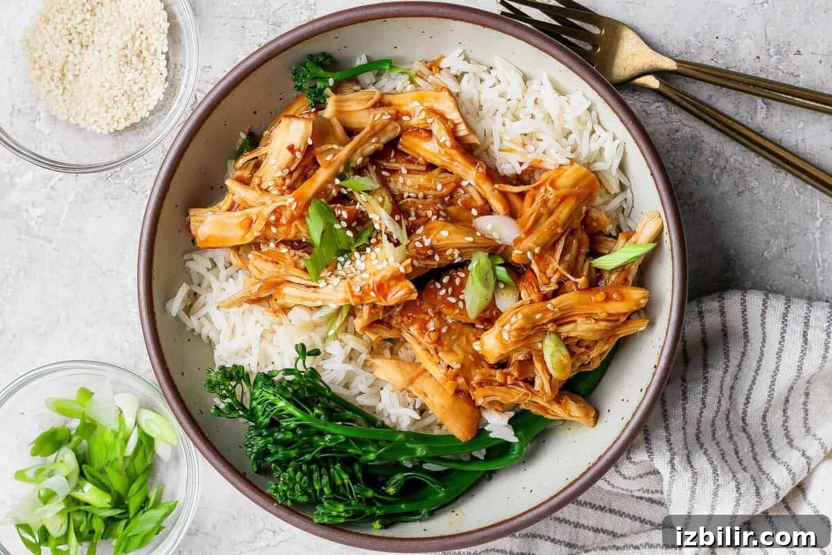 Sticky Honey Garlic Chicken Recipe 2 Crockpot honey garlic chicken served over white rice with broccolini in a bowl