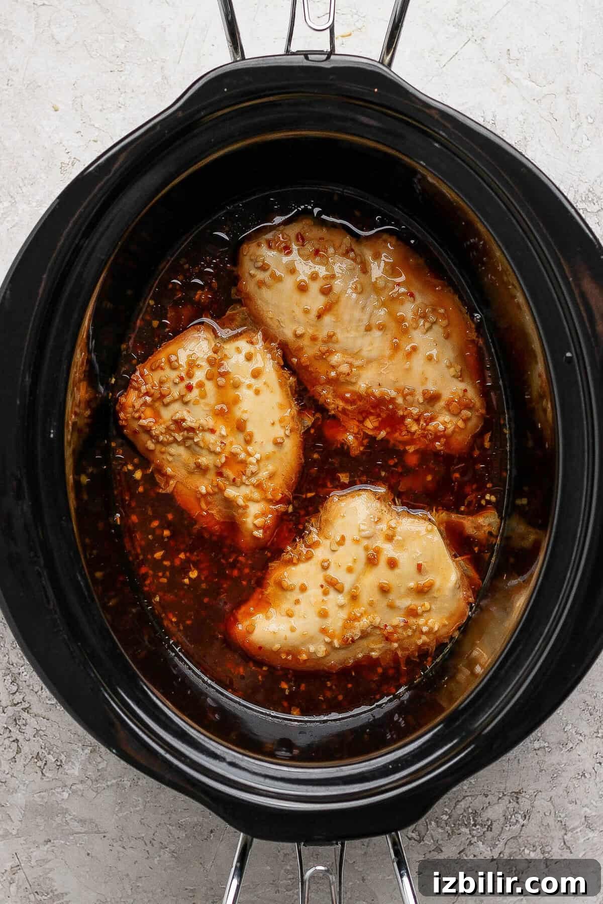 Sticky Honey Garlic Chicken Recipe 4 Honey garlic chicken breasts cooking in a slow cooker with sauce