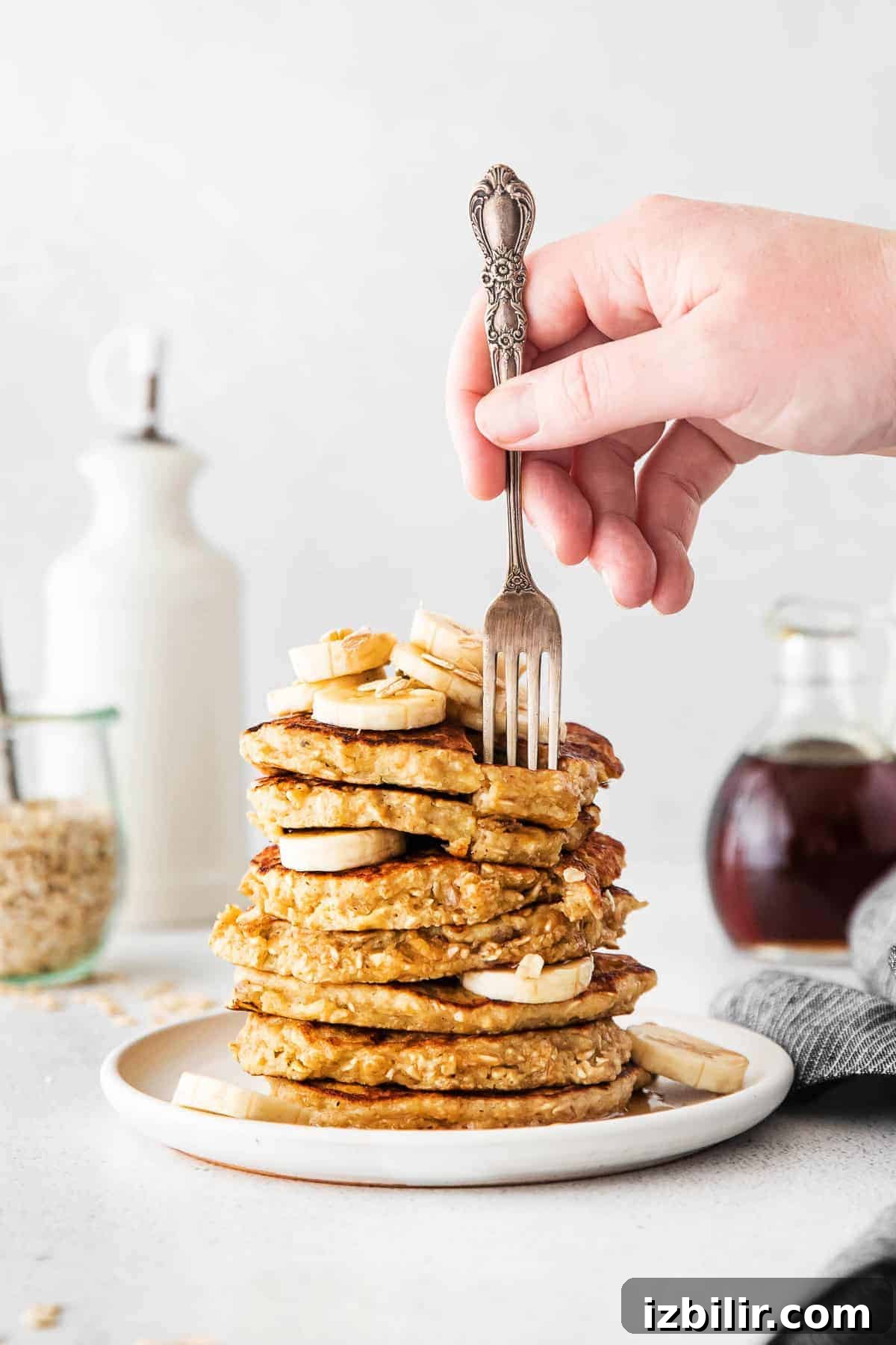 Fluffy Banana Oatmeal Pancakes Recipe 2 fork biting into pancake stack