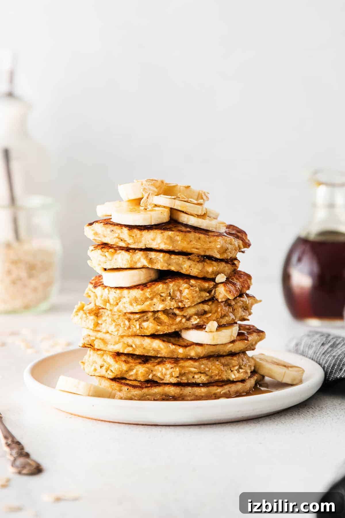 Fluffy Banana Oatmeal Pancakes Recipe 7 stack of pancakes with banana and oatmeal on top