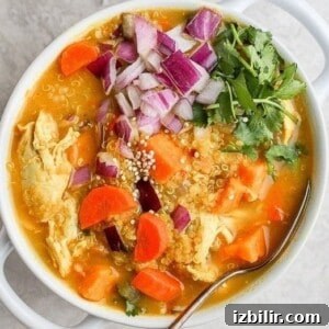 One-Pot Golden Chicken Curry Soup Recipe 7 A bowl of chicken curry soup with carrots and onions.