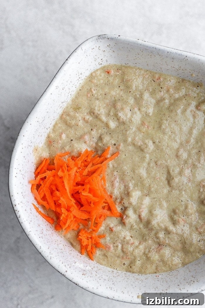 Mixing the batter for carrot cake pancakes. healthy carrot cake pancake ingredients in a bowl