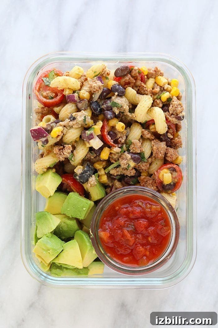 Taco Pasta Salad Recipe with Ground Beef, Cheddar and Corn 11 Meal Prep Container with taco pasta salad, avocado, and salsa.