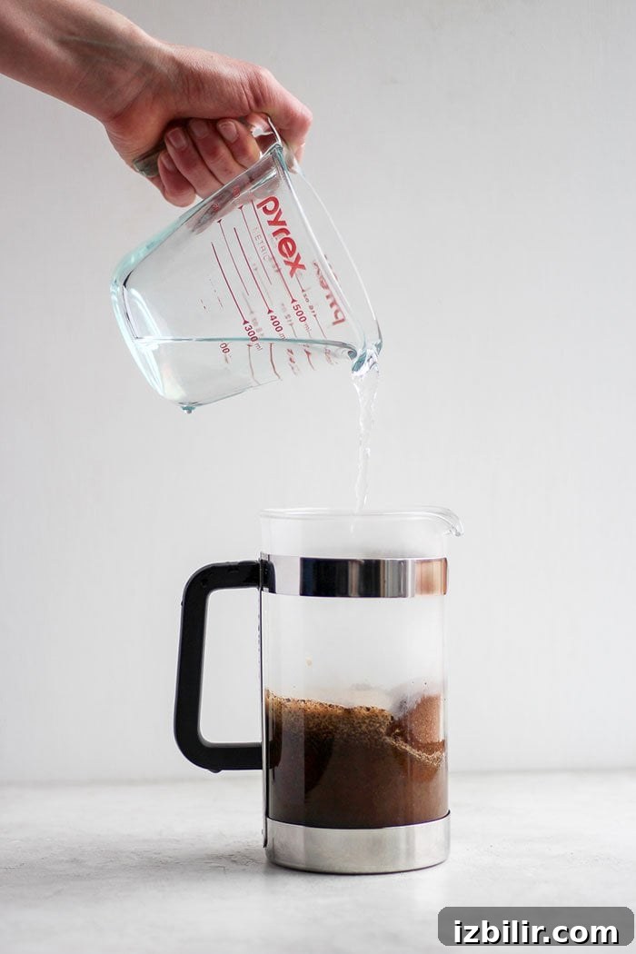 Start the day off right with the perfect cup of French press coffee! Pouring hot water into a French press.