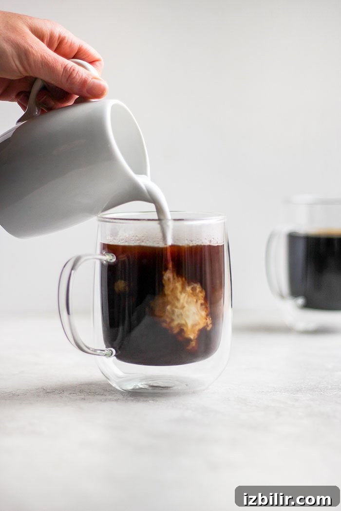 Start the day off right with the perfect cup of French press coffee! Pouring cream into a cup of coffee.