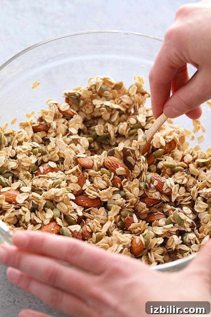 Mix the dry ingredients before adding the syrup and oil Mixing all the ingredients for healthy granola in a bowls.