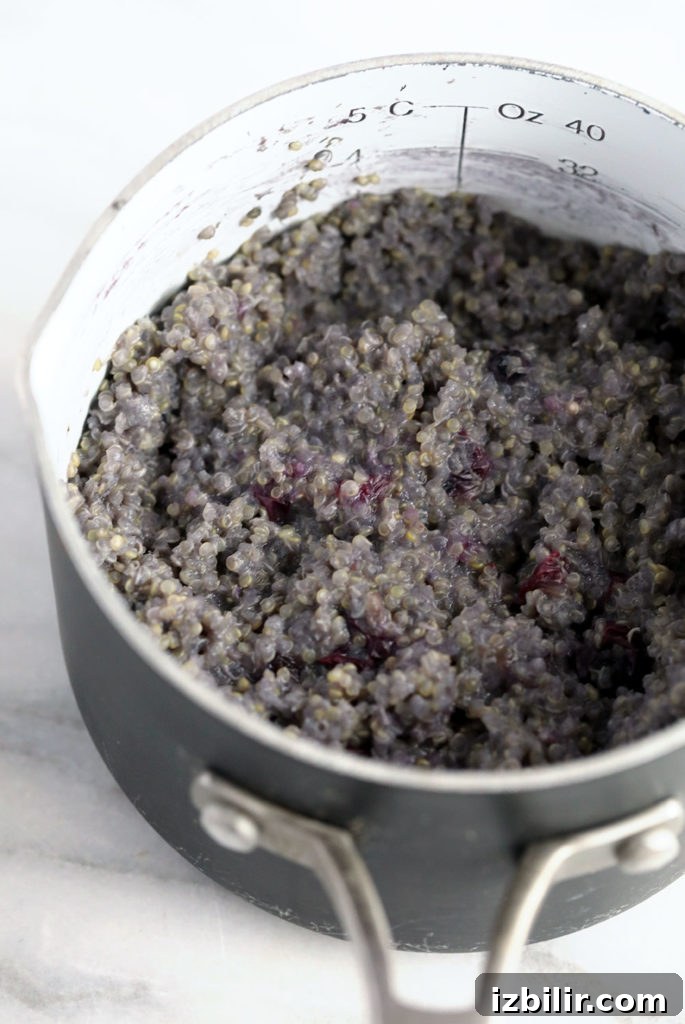 Blueberry breakfast quinoa being cooked in a pot. 