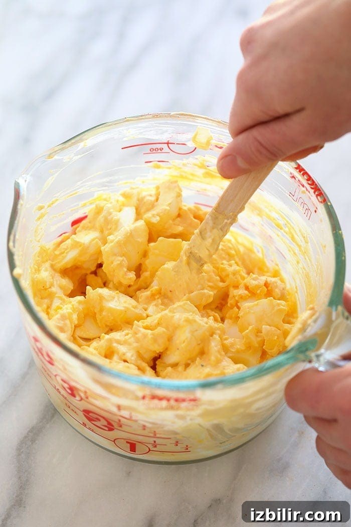 Healthy egg salad ingredients being mixed together.