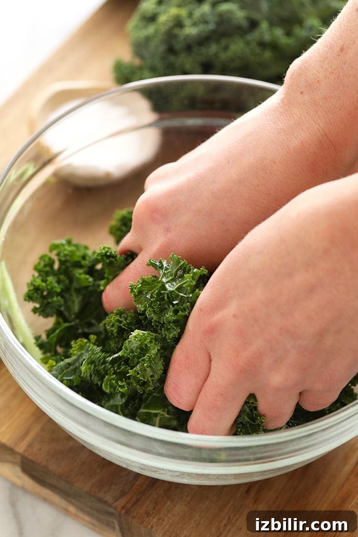 Two hands massaging kale