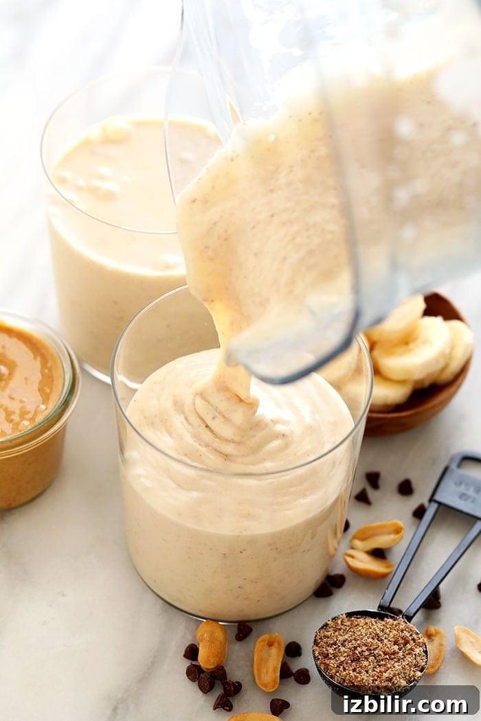 Peanut butter and banana is a fan favorite when it comes to flavor combos. That's why this peanut butter banana smoothie is a show-stopping smoothie recipe you need to make! We kept this peanut butter and banana smoothie recipe simple with just 6 total ingredients! Keep reading to get the recipe and dig in! pouring smoothie into glass.