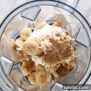 a blender filled with bananas and whipped cream, creating a mouthwatering banana smoothie