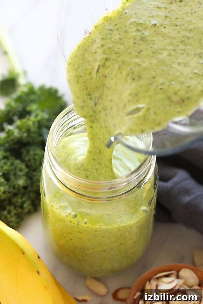 Kale smoothie being poured from a blender to a mason jar kale smoothie being poured from a blender to a mason jar.