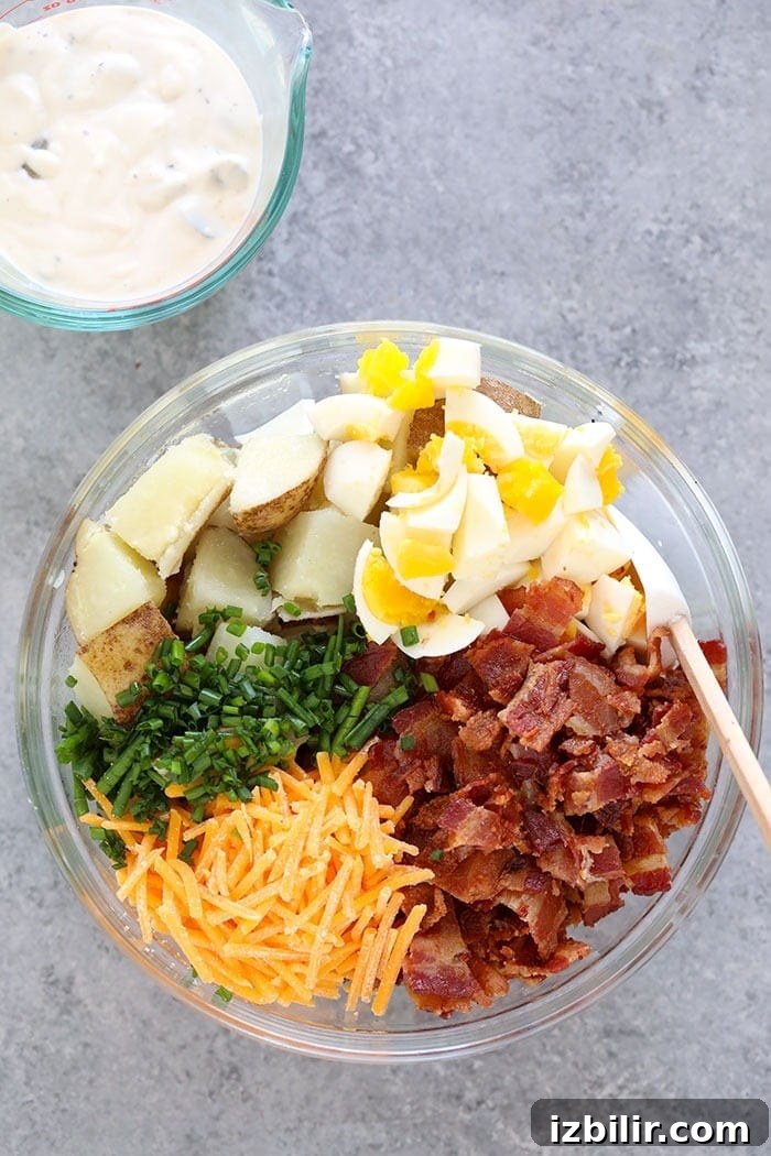 This baked potato salad recipe is loaded with cheddar cheese, hard boiled eggs, bacon, chives, and a delicious dill pickle sauce! Ingredients for loaded potato salad