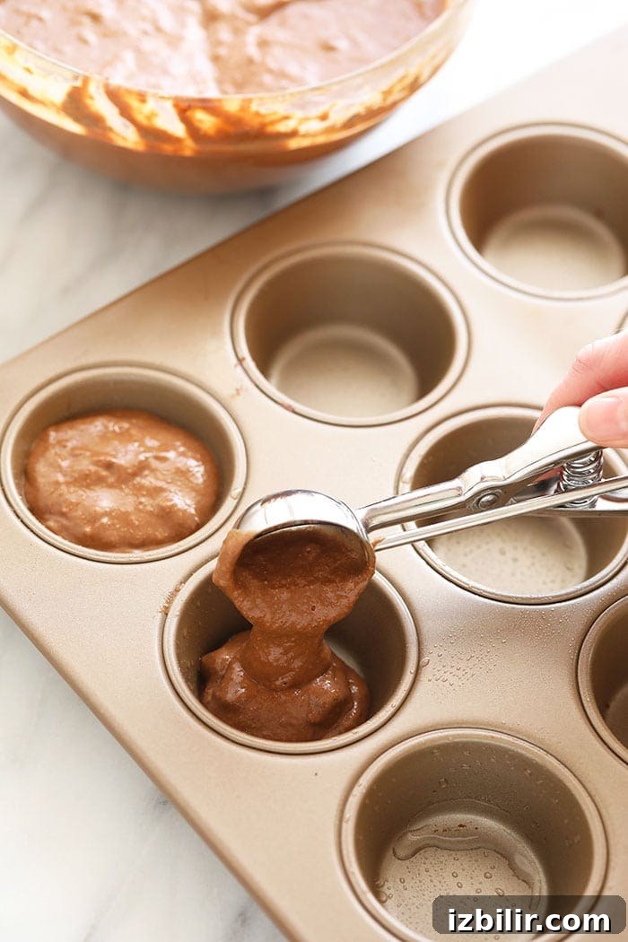 Chocolate Muffins Recipe: Wholesome Morning Treats 4 Scooping healthy chocolate muffin batter into a muffin tin