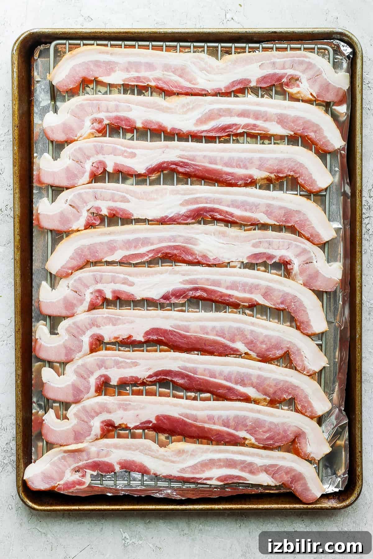 sliced bacon on a baking sheet.