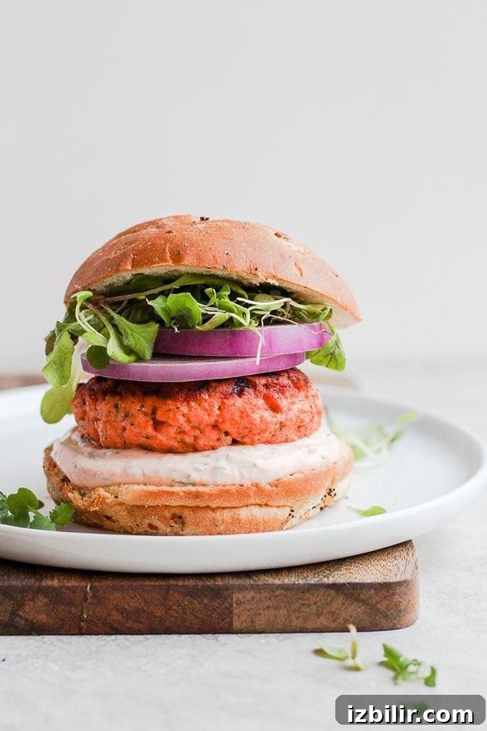Salmon burgers plated with greens salmon burgers on a plate