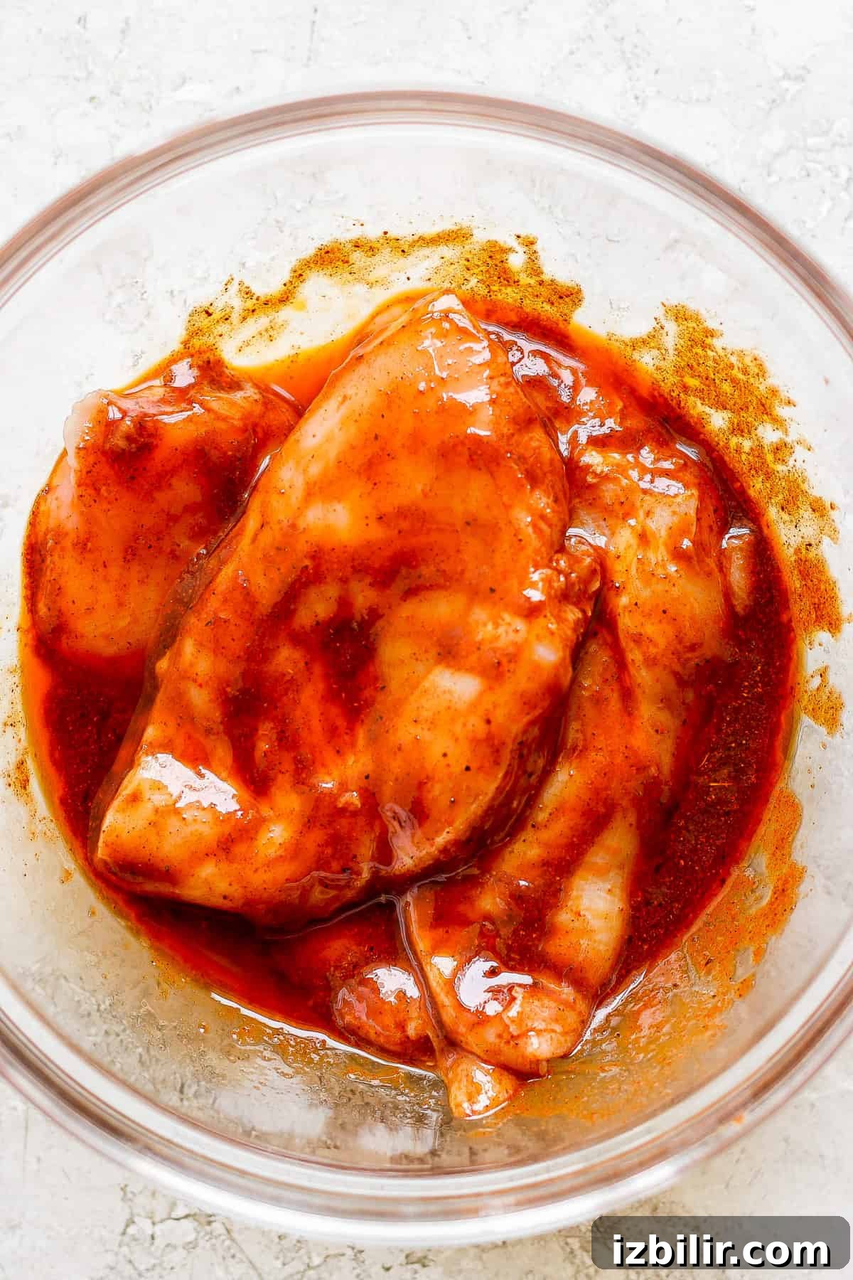 a bowl of chicken with sauce in it.