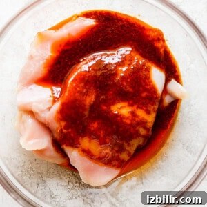 a piece of chicken in a bowl with sauce on it.