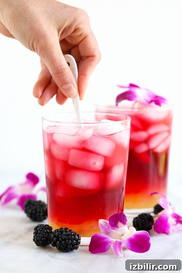 Stirring the Hibiscus Arnold Palmer arnold palmer drink being stirred in a glass with a spoon