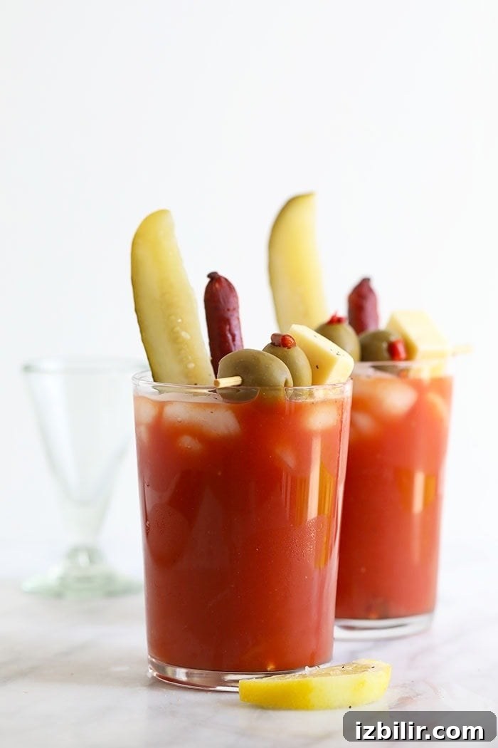 Bloody Mary in a glass with pickles, olives, and cheese