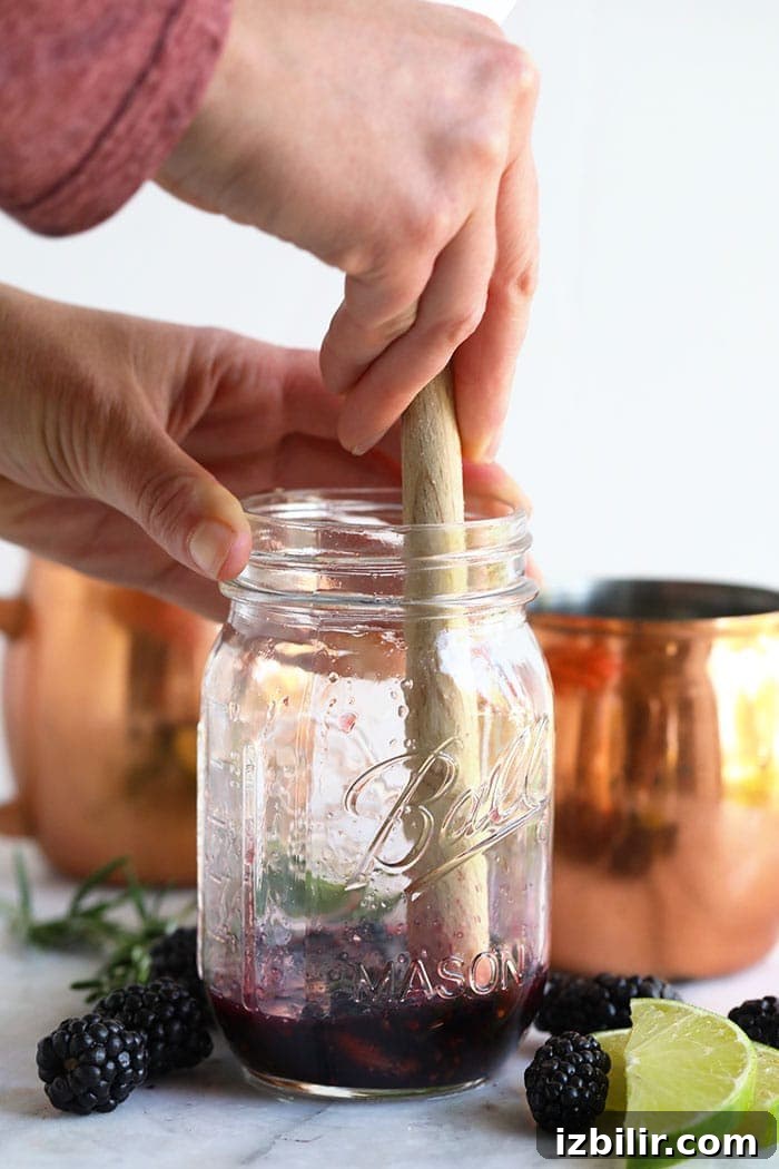Muddling blackberries and mint hand muddling blackberries