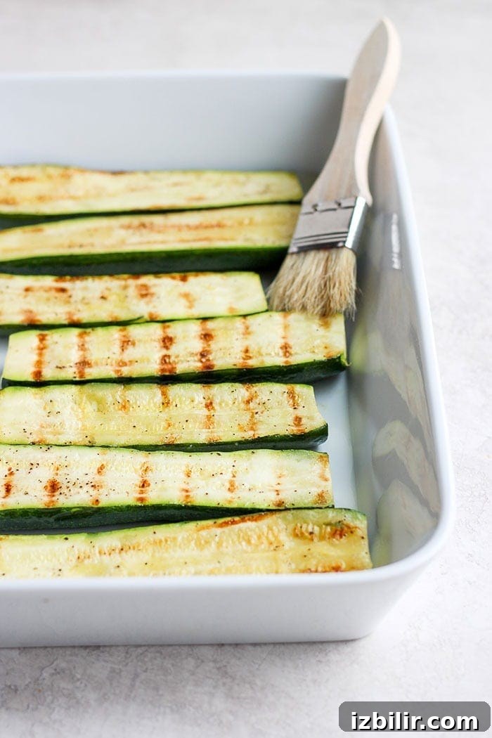 Turn on the grill and throw on some zucchini! Making grilled zucchini is easy and if you do it right you'll end up with grilled zucchini with a little crunch rather than a soggy mess. Grab the zucchini from your garden or the grocery store and get grilling! grilled zucchini in a baking dish.