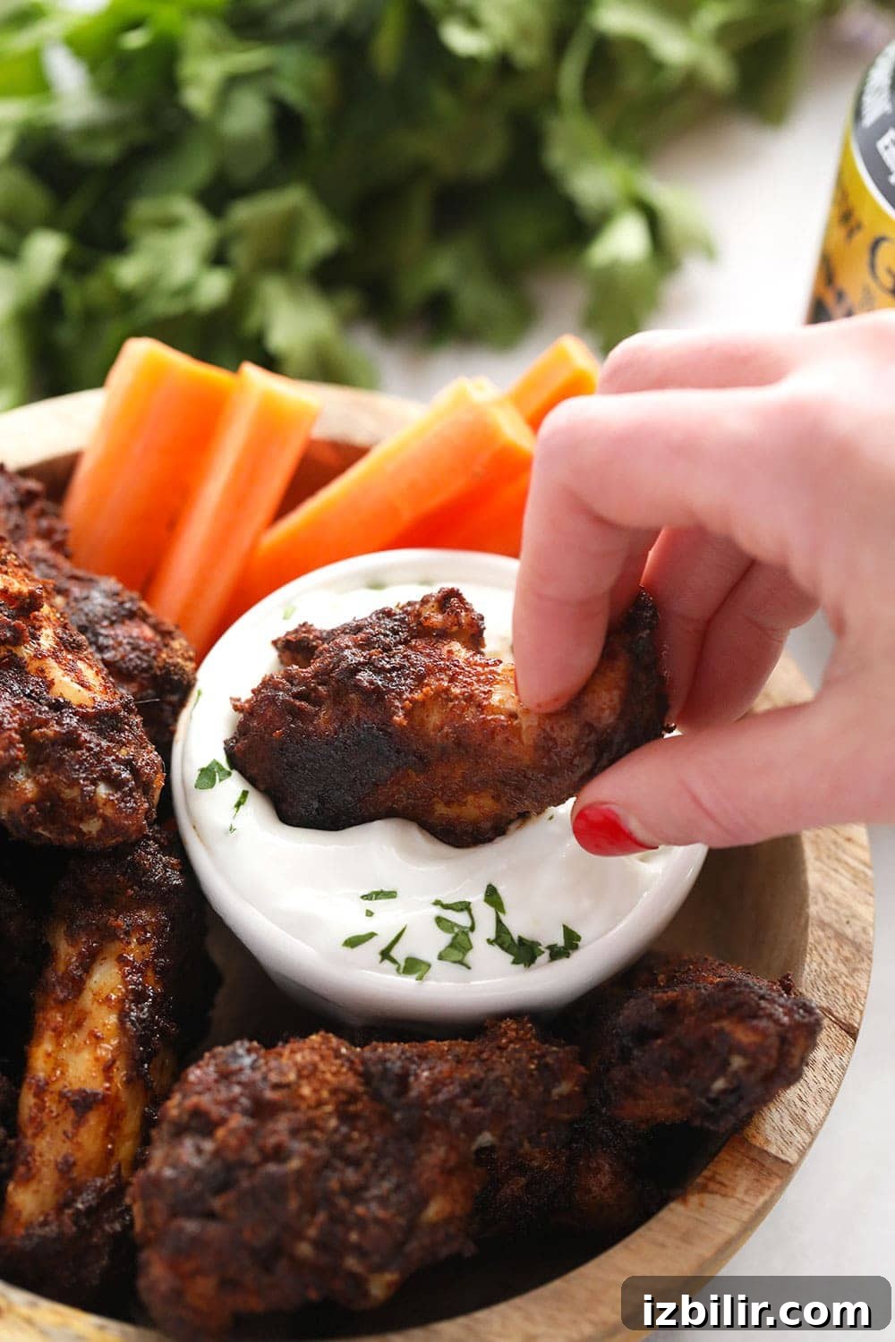 Dipping a wing into blue cheese dressing Dipping a chicken wing into blue cheese dressing