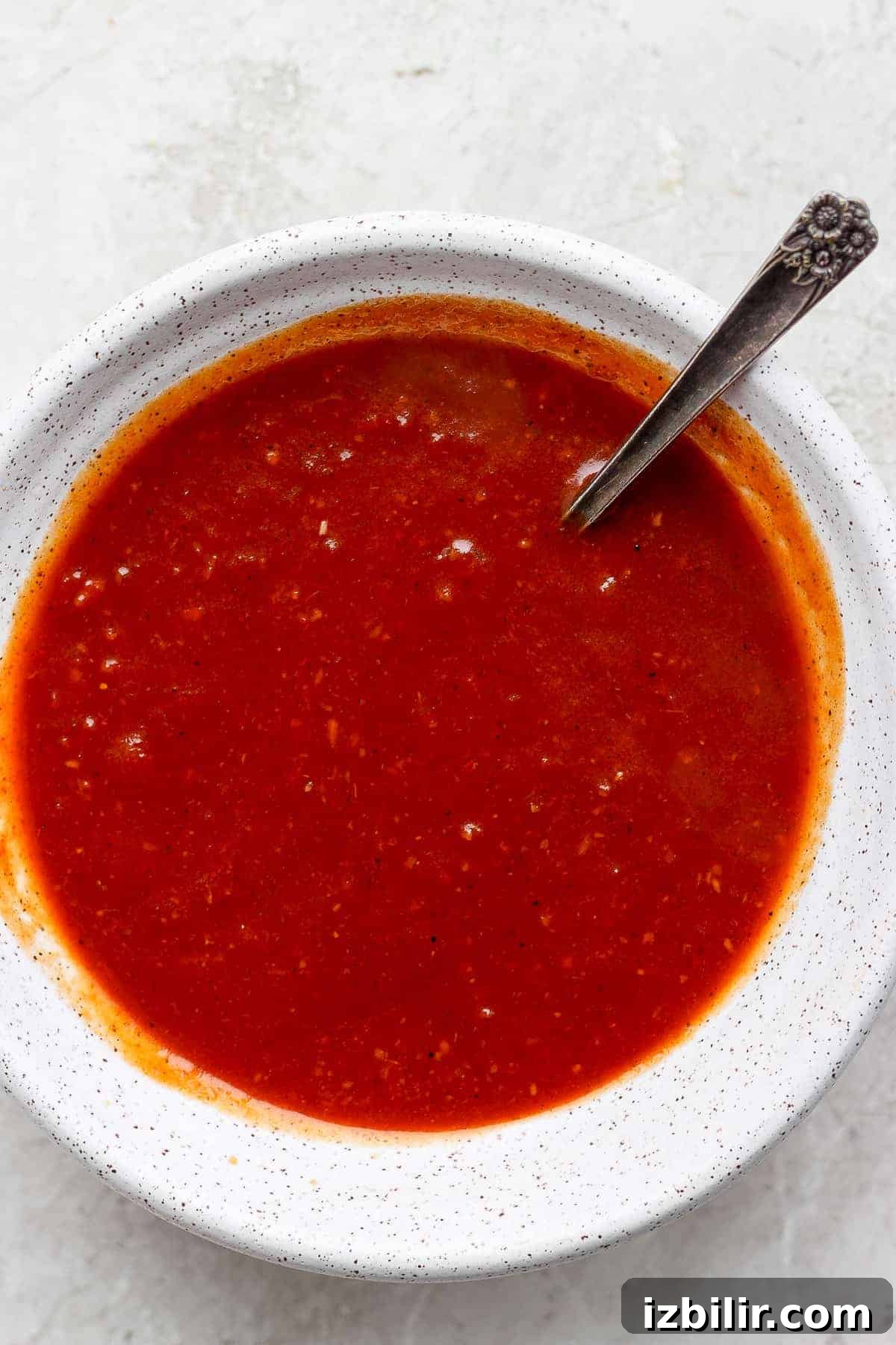 homemade BBQ sauce in a bowl with a spoon.