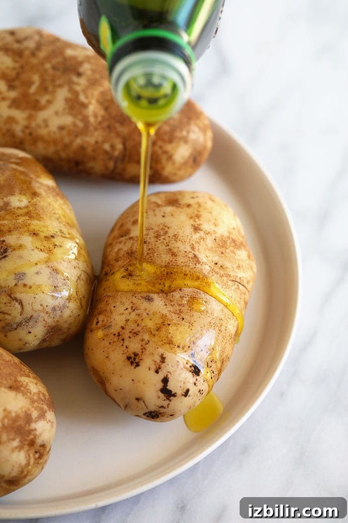 Crispy Foil-Wrapped Baked Potatoes 3 olive oil drizzling on baked potatoes