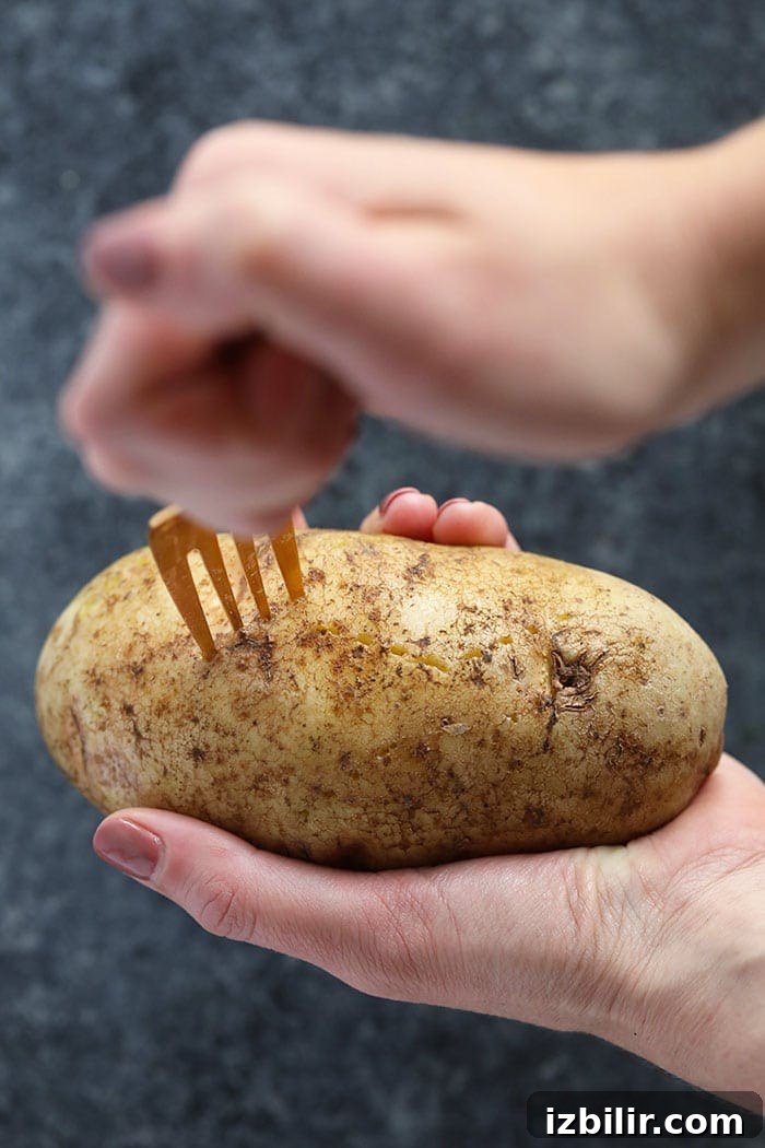 crock pot baked potato being speared with a fork