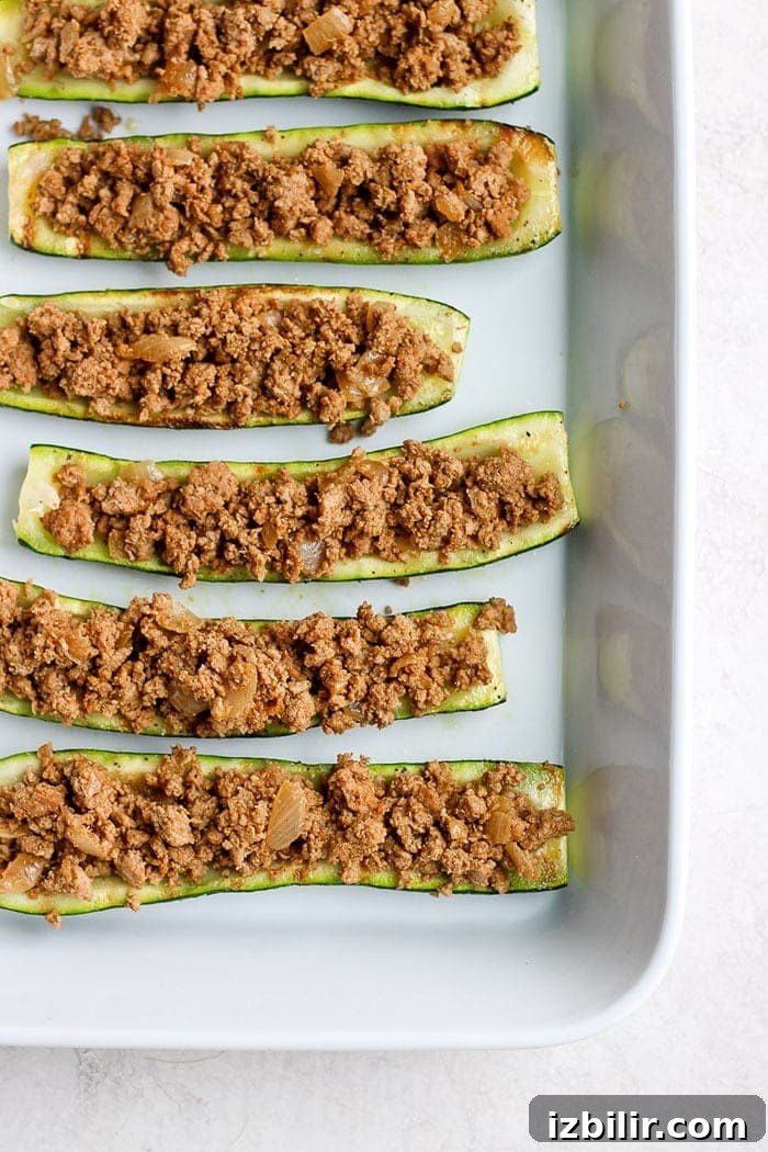 taco zucchini boats ready to be topped with cheese and finished on the grill