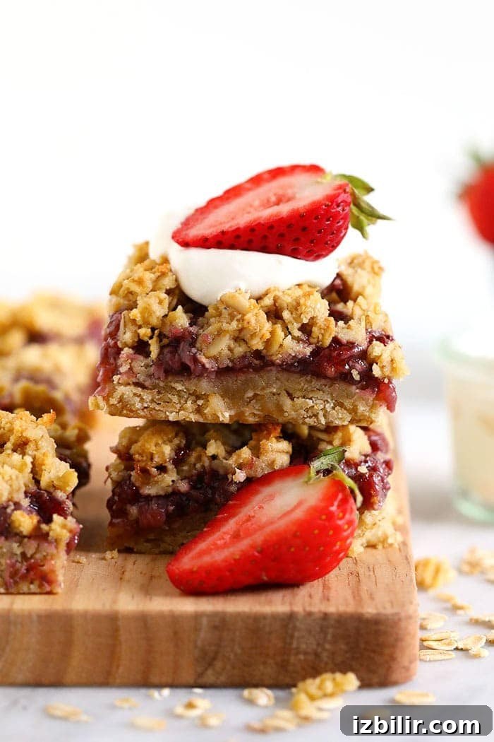 Strawberry Oatmeal Bars Recipe 3 healthy strawberry oatmeal bars stacked and topped with fresh strawberries