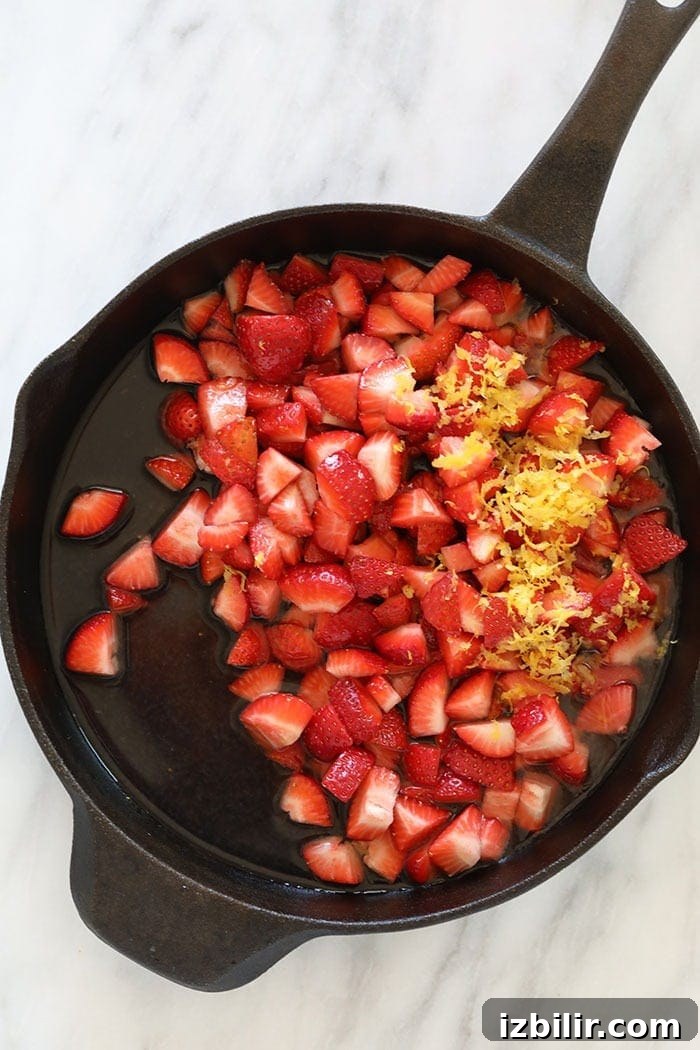 Strawberry Oatmeal Bars Recipe 5 sliced strawberries in a cast iron skillet ready to be reduced