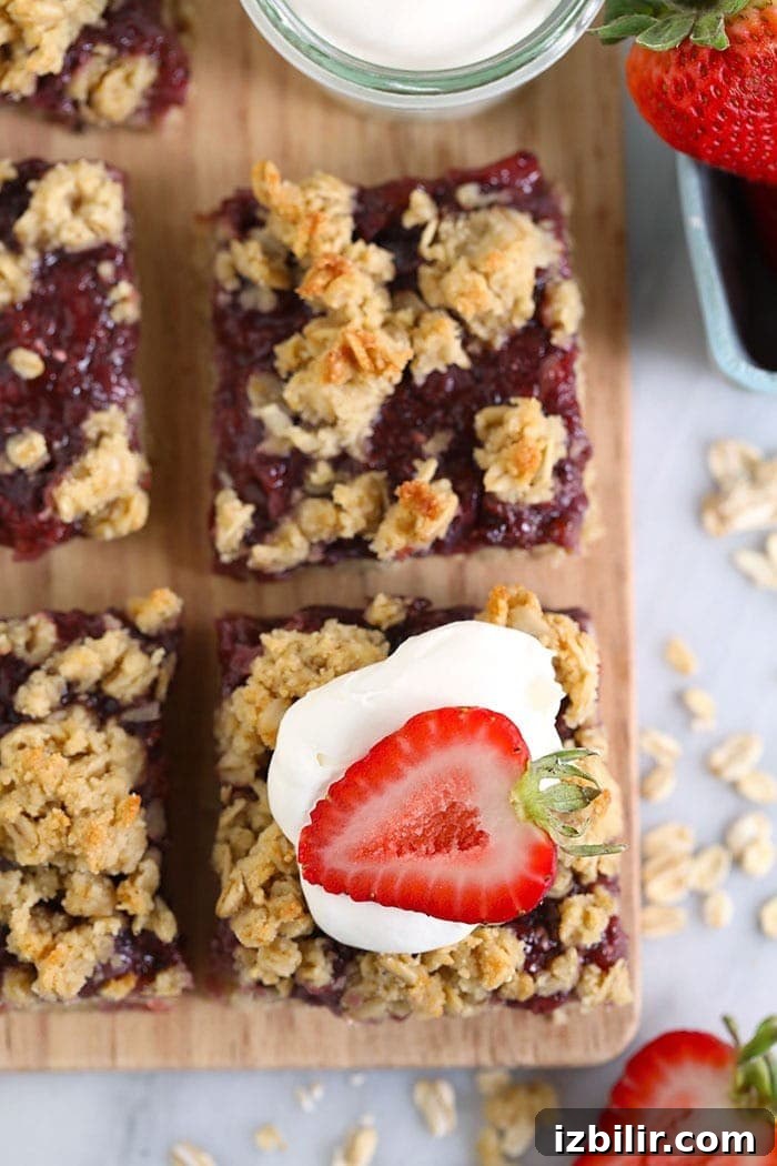 Strawberry Oatmeal Bars Recipe 7 sliced strawberry oatmeal bars topped with whipped cream and a fresh strawberry