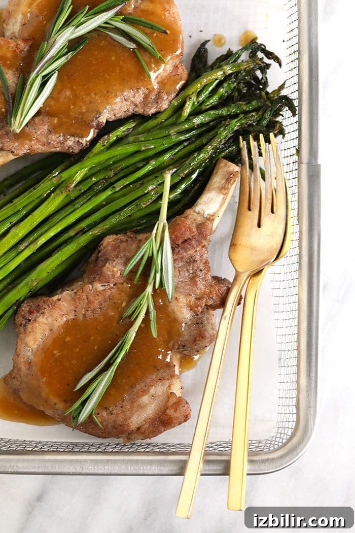 Make the juiciest, most flavorful Instant Pot Pork Chops for dinner tonight! These bone in pork chops are made with a delicious spice rub and cooked with a yummy whiskey gravy to make amazing pressure cooker pork chops. pork chops and asparagus