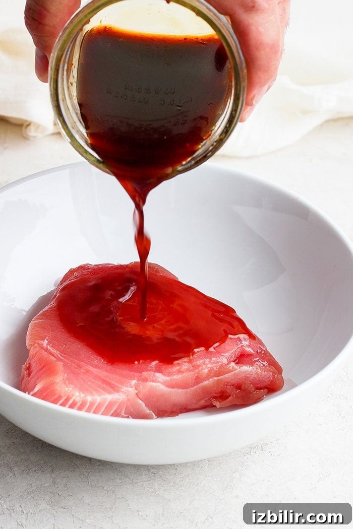 pouring marinade onto an ahi tuna steak