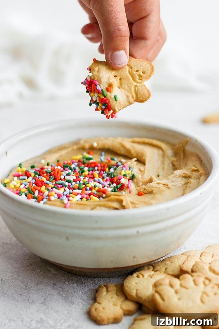 This funfetti cake batter dip is a sweet treat that is not only delicious but healthy! It's made with garbanzo beans, maple syrup, cashew butter, and vanilla. It tastes exactly like cake batter! Dipping an animal cracker into cake batter dip