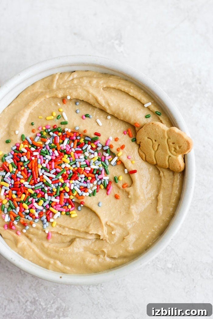 This funfetti cake batter dip is a sweet treat that is not only delicious but healthy! It's made with garbanzo beans, maple syrup, cashew butter, and vanilla. It tastes exactly like cake batter! Cake batter dip in a bowl