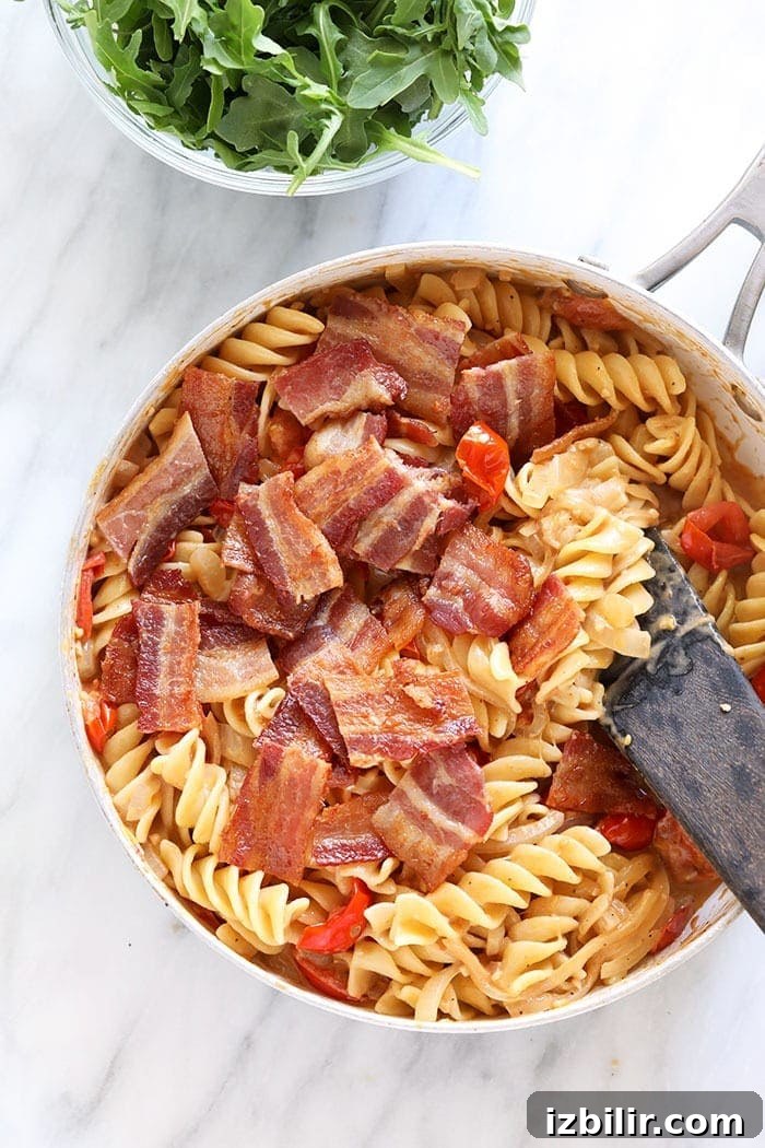 Chopped bacon being mixed into BLT pasta chopped bacon being mixed into a BLT pasta