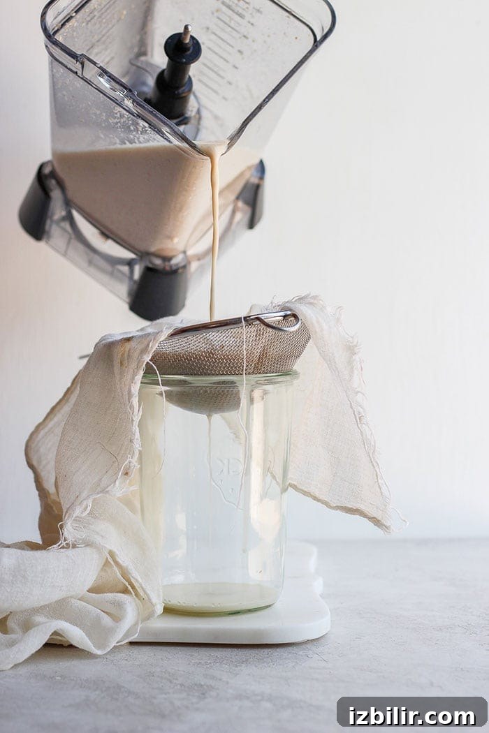 Pouring oat milk into a tea towel